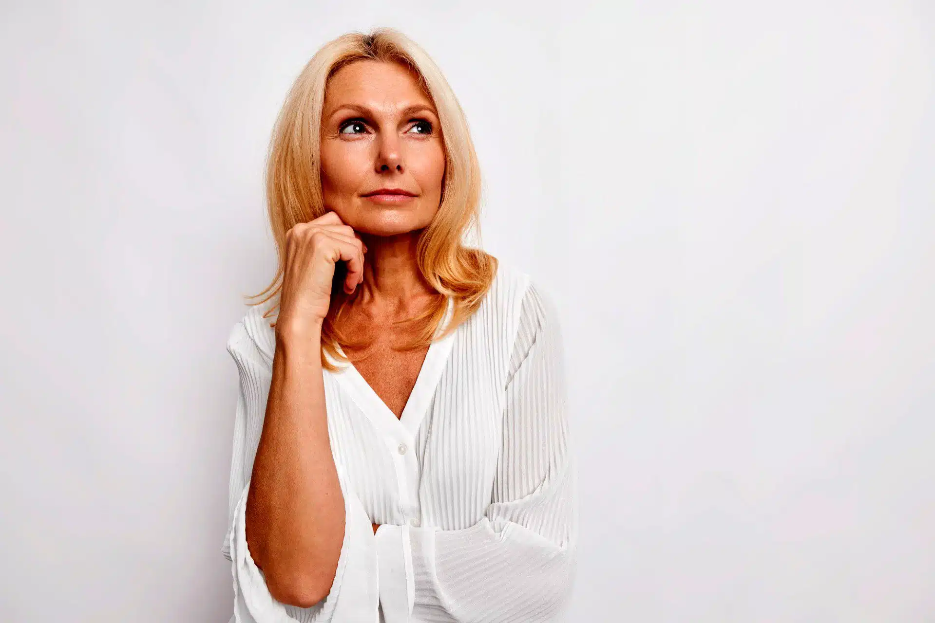 Thoughtful woman in white blouse.